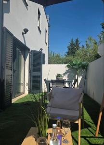 a patio with a table and chairs on the grass at La Casadrine in Le Grau-dʼAgde