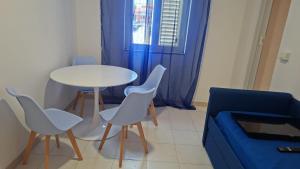 a living room with a table and chairs and a blue couch at Costadeiapartments in Briatico