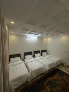a bed in a room with white sheets and pillows at شقة واسعة بحي الدوحة لـ 10 أشخاص 6دقائق للبحر in Yanbu +12 photos