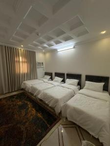 a row of four beds in a room at شقة واسعة بحي الدوحة لـ 10 أشخاص 6دقائق للبحر in Yanbu