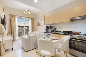 a kitchen and living room with a table and chairs at FIRST CLASS 1BR Cozy Luxury Retreat in ‘Ūd al Bayḑāʼ