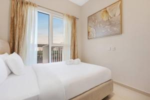 a white bedroom with a large window and a bed at FIRST CLASS 1BR Cozy Luxury Retreat in ‘Ūd al Bayḑāʼ +17 photos