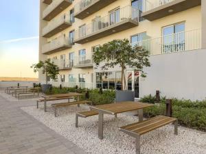 a row of benches in front of a building at FIRST CLASS 1BR Cozy Luxury Retreat in ‘Ūd al Bayḑāʼ