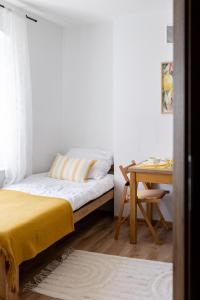 a bedroom with a bed and a desk and a table at Apartament Cytrynowy Kwidzyn in Kwidzyn
