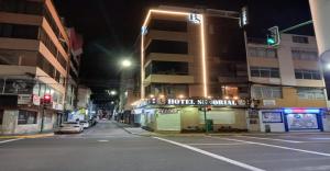 Eine Stadtstraße bei Nacht mit einer grünen Ampel in der Unterkunft Hotel Señorial in Ambato