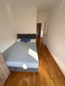 a bed in a room with a wooden floor at Modern Apartment Laktaši in Laktaši