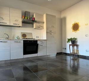 a kitchen with white cabinets and a black dishwasher at art apartament cerea in Cerea +6 photos