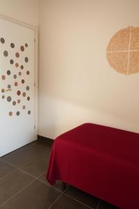 a bedroom with a red bed and a white wall at art apartament cerea in Cerea