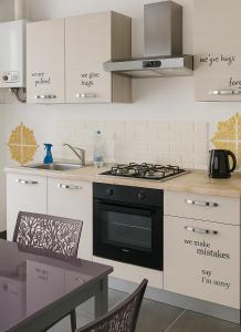 a kitchen with a stove and a table with chairs at art apartament cerea in Cerea