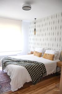 a bedroom with a large bed with a checkered wall at Alazne Enea in Bermeo