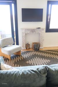 a living room with a fireplace and a tv on the wall at Alazne Enea in Bermeo