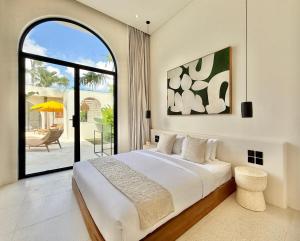 a bedroom with a bed and a large window at Dolce x The Young Villas in Uluwatu +133 photos