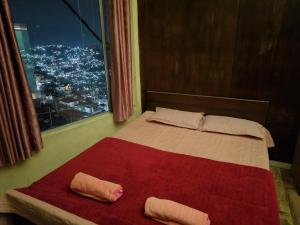 a bed with two pillows on it in a room with a window at Mizotel in Āīzawl