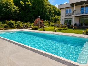 a swimming pool in front of a house at LUX Villa Mavrovo in Mavrovo +8 photos