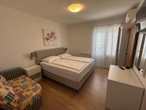 a small bedroom with a bed and a couch at Haus Lupić in Rab