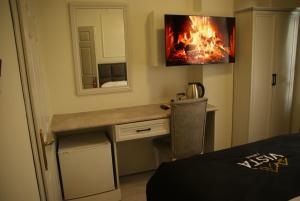 a room with a desk with a fire on the wall at Vista Kayseri Hotel in Kayseri +24 photos