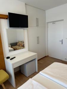a white room with a mirror and a bed at Haus Lupić in Rab