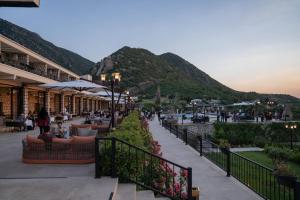 a resort with people sitting in chairs and a mountain at Crixus Hotels Sarsing in Sarsing