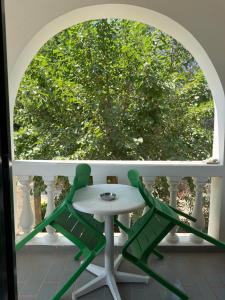 a table and two chairs on a balcony with a window at Condillia II in Spetses