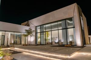 a large building with glass windows at night at Hummingbird Dubai in Dubai