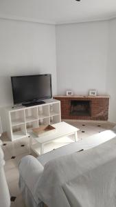 a white living room with a tv and a couch at Duplex Los Chanchez in Aguadulce