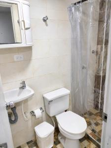a bathroom with a toilet and a sink and a shower at Central Apartment Salento Colombia in Salento
