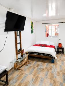 a bedroom with a bed and a flat screen tv at Central Apartment Salento Colombia in Salento +5 photos