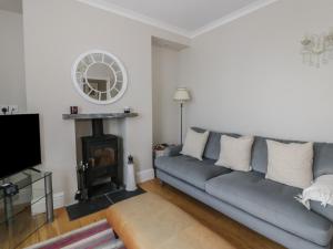 a living room with a couch and a fireplace at Arosfa in New Quay