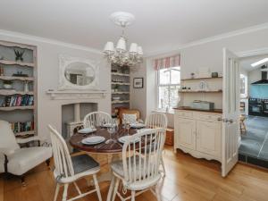 a kitchen and dining room with a table and chairs at Arosfa in New Quay