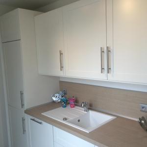 a kitchen counter with a sink and white cabinets at Julie's Apartment Disneyland in Serris