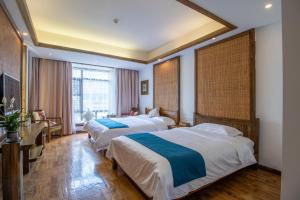 a hotel room with two beds and a desk at Zhangjiajie Yun Hai Hotel- Ancient Chinese Style Hotel,Tea Culture Experience, Realxing Class,Free Breakfast ,Local Travel Guide and Book Tickets, Gem Perporty in Zhangjiajie +73 photos