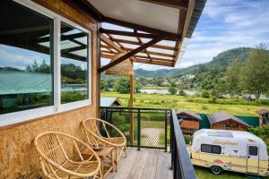 a balcony with chairs and an rv with a view at Seaside Dorm Cenang in Pulau Tepur