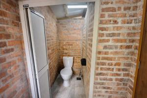 a bathroom with a toilet in a brick wall at Seaside Dorm Cenang in Pulau Tepur