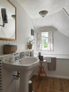 a white bathroom with a sink and a mirror at 3 Bedrooms, 3 Double Beds, 6 Guests, Countryside Thatched Cottage in Four Marks +79 photos