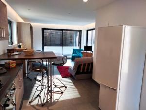 a kitchen with a refrigerator and a table and chairs at Au petit Mittlach in Mittlach