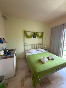 a bedroom with a green bed with towels on it at Condillia II in Spetses +130 photos