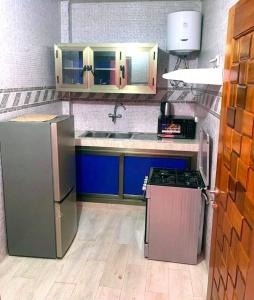 a kitchen with a refrigerator and a sink at Hotel Résidence Awa Plazza 2 in Dakar