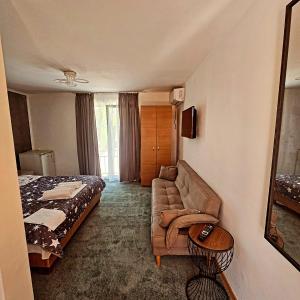 a hotel room with a bed and a couch at Vila Dedy in Costinesti