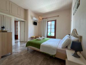 a bedroom with a large bed with a green blanket at Condillia II in Spetses
