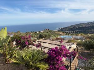 a view of the ocean from a hill with flowers at Bella Vista Poggi 180Grad fantastischer Meerblick & Pool in Poggi