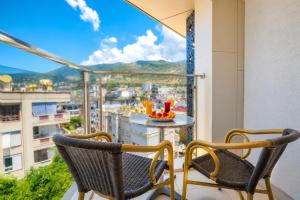 two chairs on a balcony with a view of a city at Kleopatra Micador Otel in Alanya