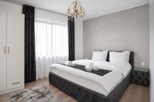 a bedroom with a large bed with a chandelier at Cataleya House Sovata in Sovata