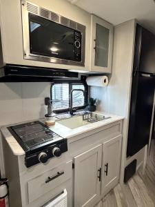 a kitchen with a stove and a microwave at Sin Ancla in Boqueron