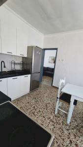 a kitchen with a refrigerator and a table in it at Xilagani Central House in Xilaganí