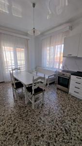 a white kitchen with a table and a stove at Xilagani Central House in Xilaganí