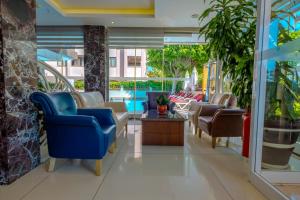 a lobby of a resort with chairs and a pool at Kleopatra Micador Otel in Alanya