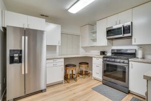 a kitchen with white cabinets and stainless steel appliances at Utah Valley Basecamp: Apt for Hikers & Explorers! in Spanish Fork