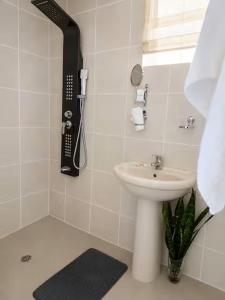 a white bathroom with a sink and a phone at Camperdown Stay in Camperdown +4 photos