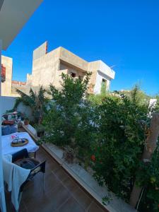 a balcony of a house with a table and plants at Villa CULUPIA in Kelibia