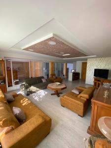 a large living room with couches and a tv at Villa CULUPIA in Kelibia
